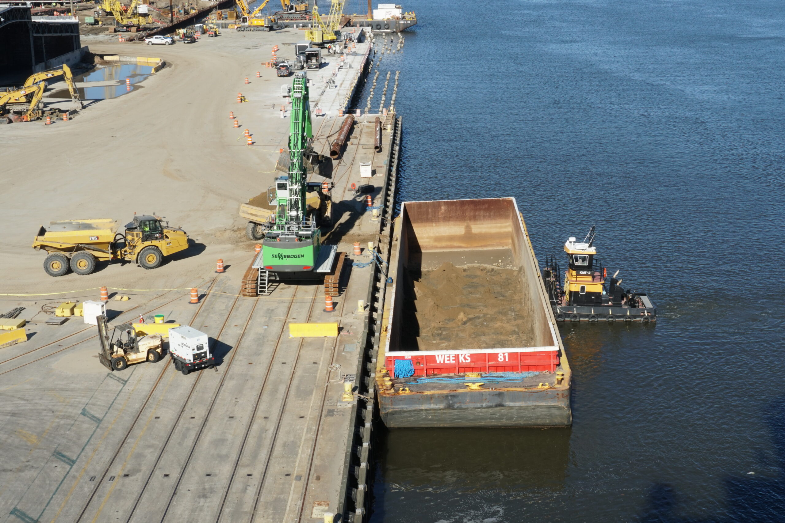 Tugboat with barge and construction of a new container terminal on a river in the south American city of Savannah.